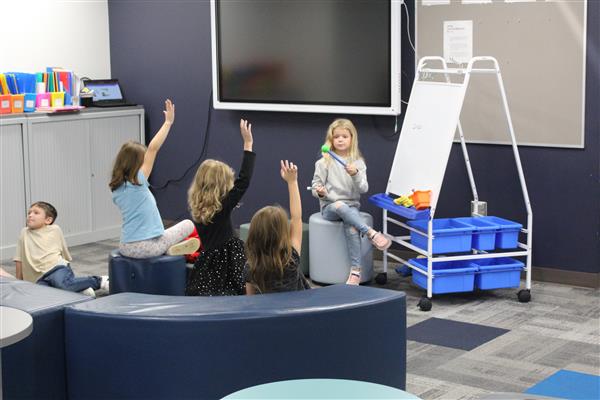 students sit together and play school